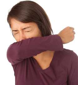 Woman coughing into arm
