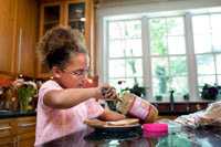 Photo: A girl making a peanut butter sandwich.