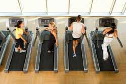 Four people walking on treadmills