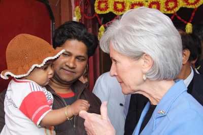 La secretaria Sebelius interactúa con un niño con síntomas de la influenza en un pueblo rural a unos 50 km de Delhi, India.
