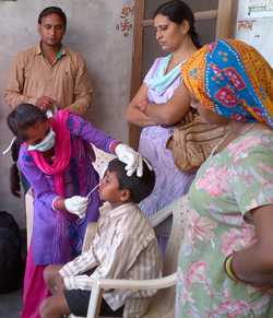 Una enfermera en India recoge una muestra nasal de un niño como parte de un estudio de vigilancia a domicilio sobre la vacuna contra la influenza.