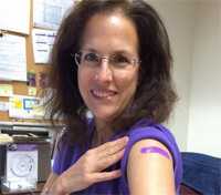 Foto de una mujer en la oficina nacional de March of Dimes mostrando el brazo donde le acaban de administrar la vacuna.