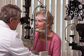 	Ophthalmologist examining a womans eyes with a slit lamp.
