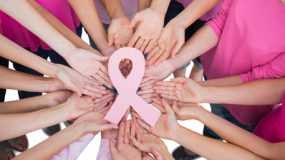 an image of hands holding a pink ribbon