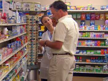Pharmacist explaining to a customer which over-the-counter medications may help relieve his symptoms.