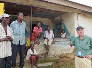 Peter Kilmarx talking to headman and family in a quarantined village, Port Loko District, Sierra Leone
