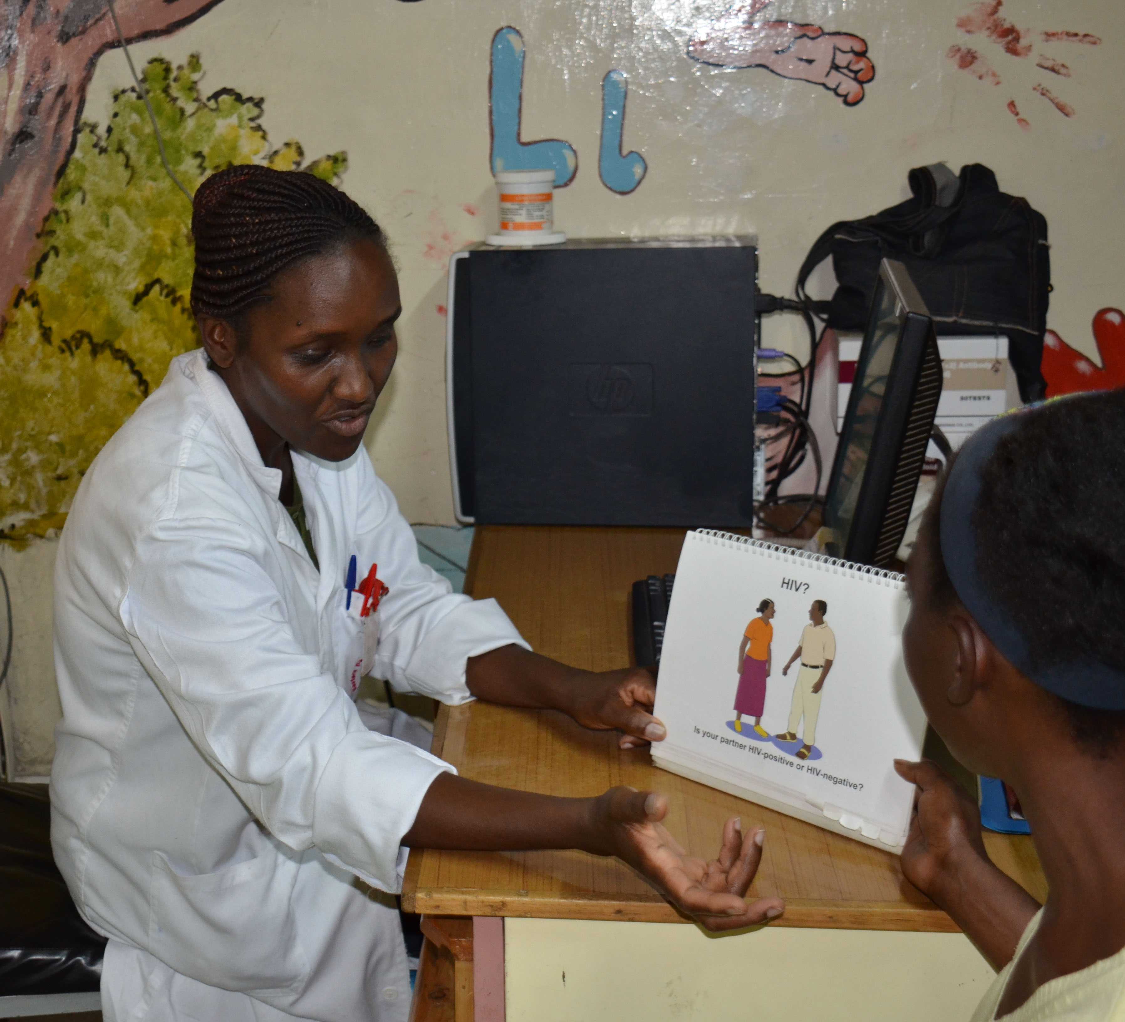 Jelius Muraguri, PMTCT nurse at EDARP, discusses HIV prevention and care with one of the mothers attending CDC- supported Komarock Clinic.