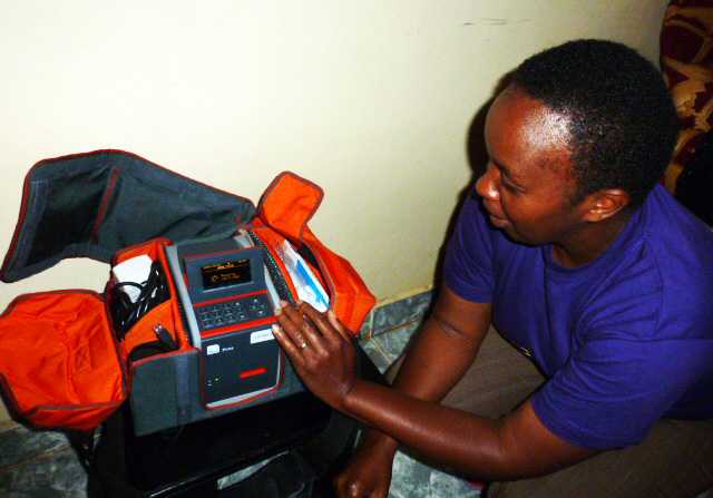 A lab technician performs quality control measures on a machine that analyses CD4 counts from blood specimens collected during the survey.