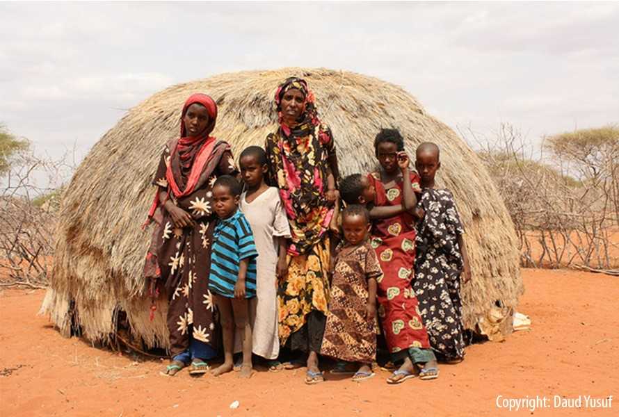	Kenyan children standing in front of a hut.