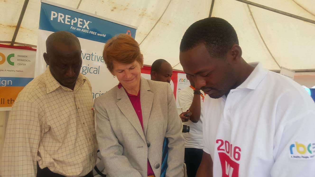 Dr. MacDonald of CDC Rwanda watches as Dr. Japhet of PREPEX demonstrates a product.