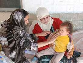 Pakistan FELTP resident Dr. Najma Javed checks for the Bacillus Calmette-Guérin (BCG) vaccine scar on the shoulder of a young child. The BCG vaccine protects children against tuberculosis.