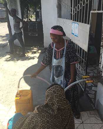 	Filling water jugs to take home (Source: Anu Rajasingham, CDC)