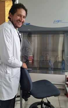 Microbiologist Dr. Andrés Montilla stands next to a cabinet purchased by the project