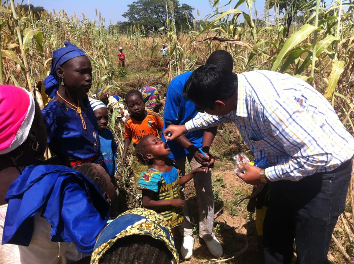 In some instances, the dense plant life that isolates communities is not a forest. In Nigeria, large crops can hide the homes of people in various communities. Stop Transmission of Polio (STOP) team member Yatender Singh administers vaccinations on a hard to reach farm in Nigeria. 