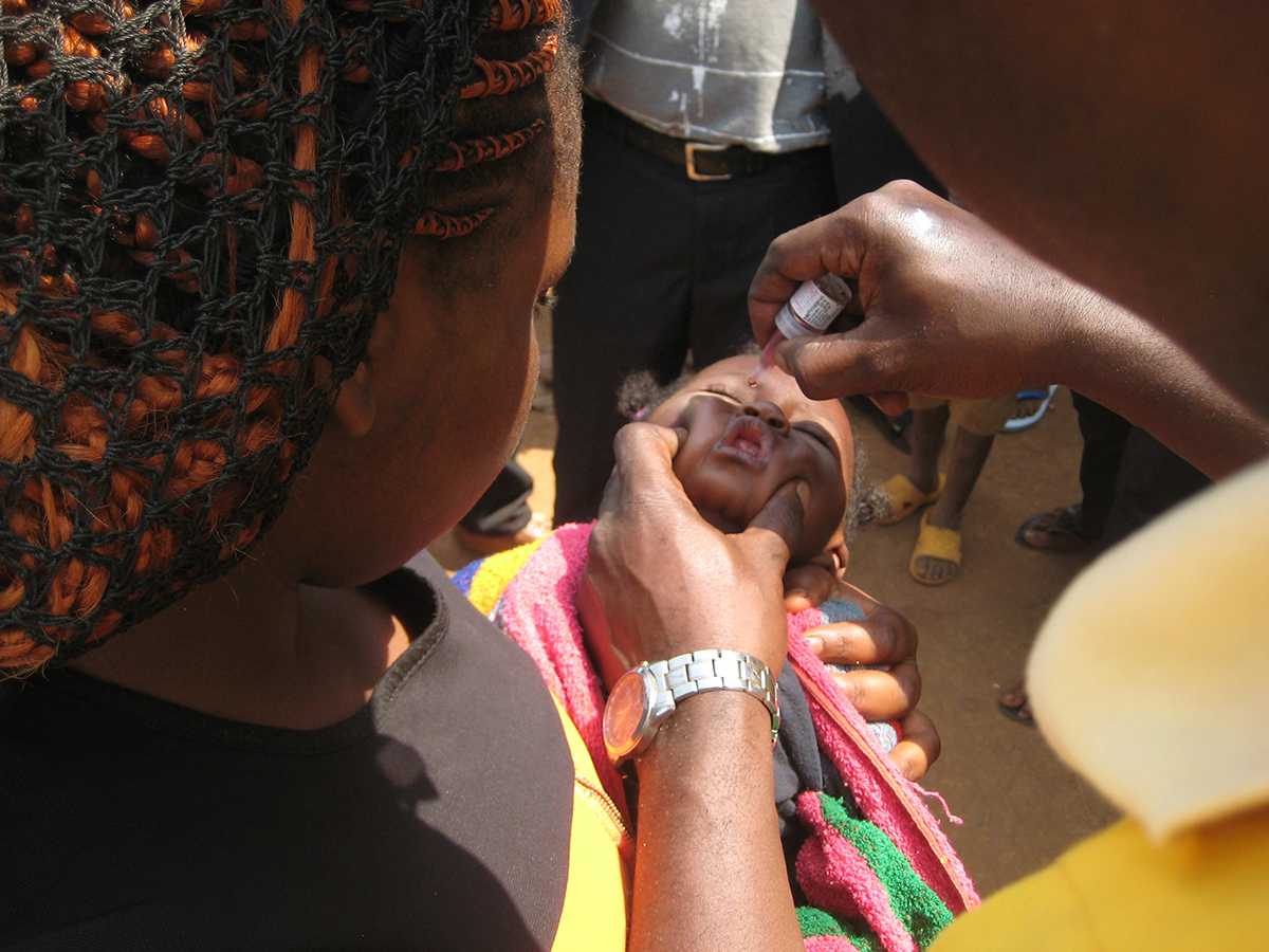 Cameroon: A child in the arms of her mother receiving her dose of the oral polio vaccine.