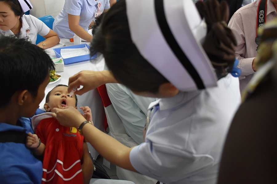 In the second picture shows a child is being vaccinated with OPV at the official STOP ISDS Lao PDR pilot launch ceremony. 