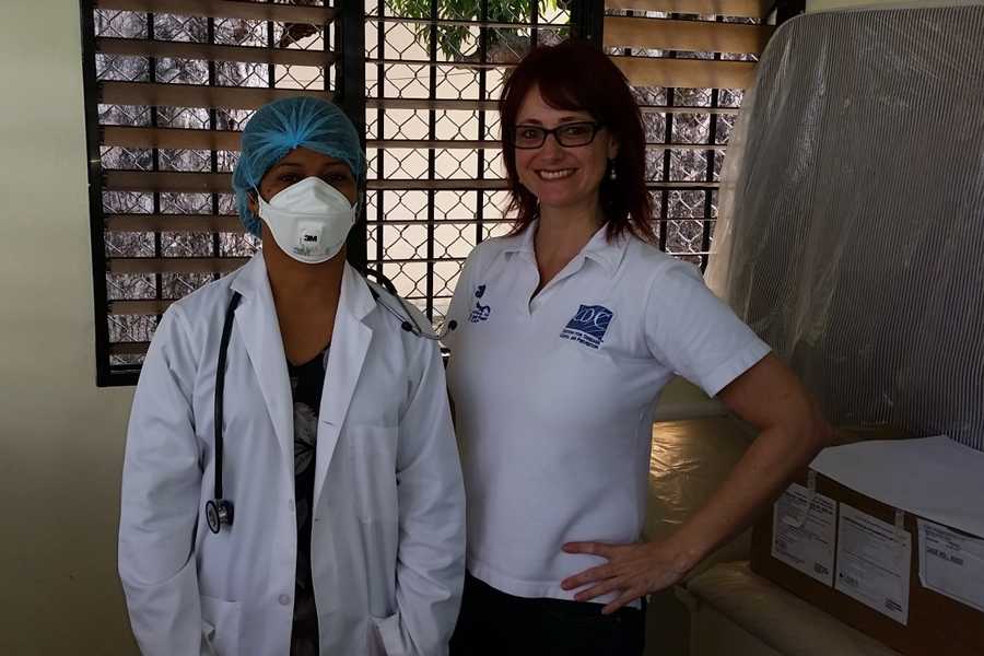 Dr. Diana Forno, CDC-Central America Regional (CAR) Office Tuberculosis/HIV Epidemiologist (right) with a TB clinic physician demonstrating the use of personal protective equipment during a TB infection-control training and facility risk assessment in the Dominican Republic. Photo source: CDC-CAR