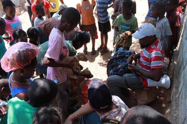 Children bring their dogs to vaccination post in Haiti.