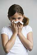 girl wiping nose after sneezing