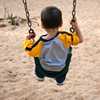 	Photo of a boy on a swing over sand