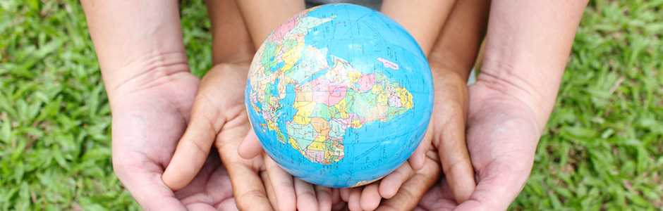 Kids hands holding a small globe
