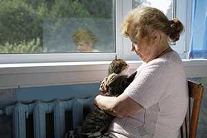 A woman holds her cat.