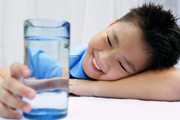 young boy looking at glass of water