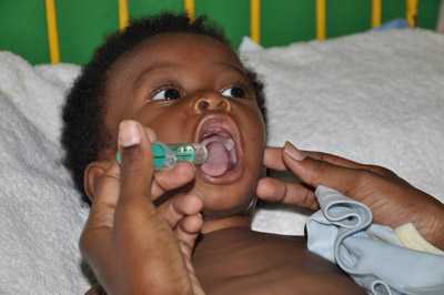 	a child in the developing world getting an oral vaccination