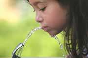 	Photo of a girl drinking from a water fountain