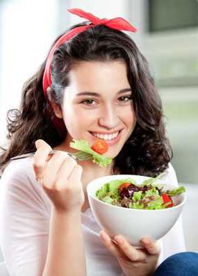 Photo: Young woman eating a salad