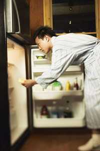 foto de un hombre frente a un refrigerador abierto