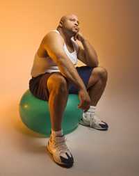 foto de un hombre pensando, sentado en una pelota de gimnasia 