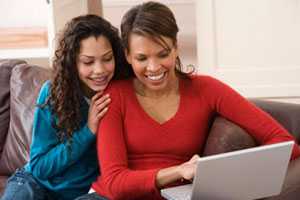 African American Daughter and Mother Looking at laptop computer