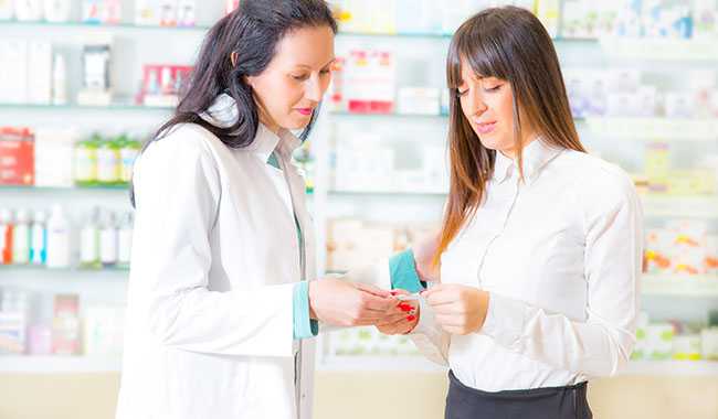 A pharmacist speaking with a customer.