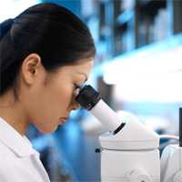photo of a woman looking into a microscope