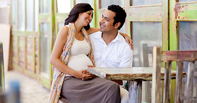Foto de una pareja, una mujer embarazada, sentada en un cafÃ©