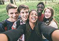 group of male and female teenagers smiling taking a photo