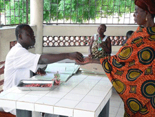 Woman receiving tuberculosis drugs at clinic in Cotonou, Benin