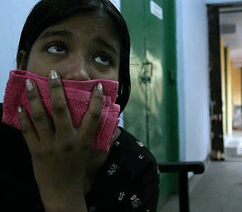 Child holding a cloth in front of her mouth