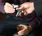 Photo of man with an alcoholic drink handing his car keys to another man