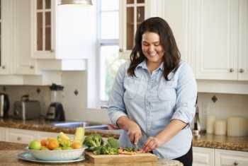 image of a woman chopping vegetables in a kitchen