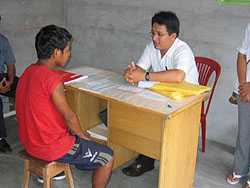 A young boy is interviewed by a health-care worker as part of CDC activities in Iquitos, Peru.