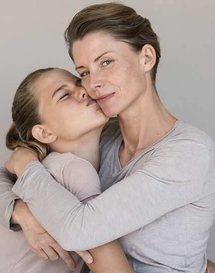 a woman and her teen daughter hugging