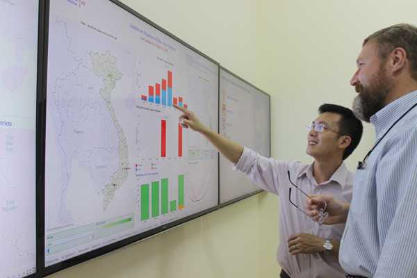 Dr Tu Anh Nguyen with CDC's Peter Rzeszotarski working on a data-visualization board of Zika cases in Vietnam