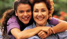 Younger woman embracing older woman from behind