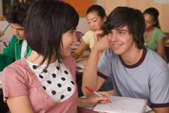 teenage boy and girl flirting in classroom