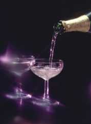 Champagne bottle pouring into a glass