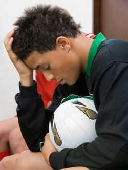 Photo: Young soccer player holding his head
