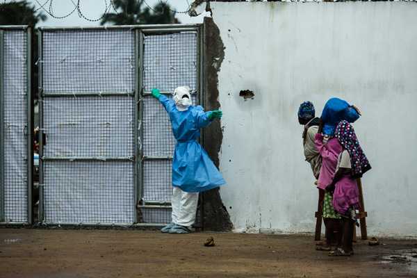 A healthcare worker opening a door for an ambulance at Ebola Treatment Unit in Liberia, 2014