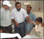 Dr. Jawad Ashgar, in Pakistan, visits a child who survived the flood waters for 12 hours before rescue.